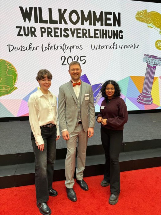 Steffen Haschlser mit zwei Abiturientinnen vom Jahrgang 2025, die ihn für den Preis nominiert hatten.